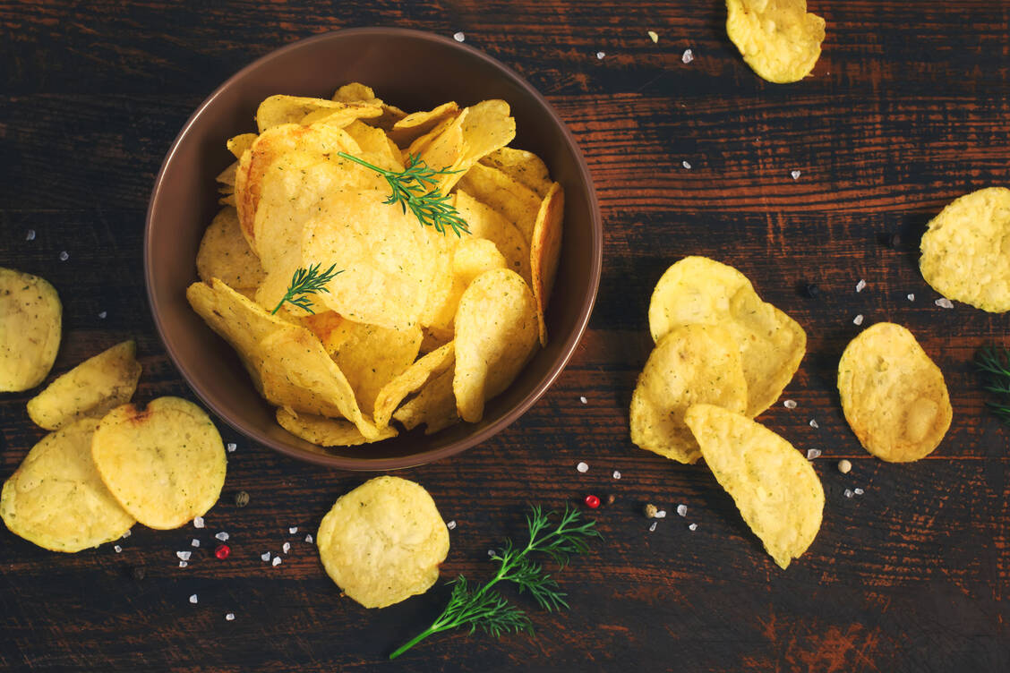 Klassische Kartoffelchips gelten zwar als Dickmacher, wenn man der Verlockung nicht wiederstehen kann, die ganze Tüte zu leeren, sie enthalten jedoch erheblich weniger Acrylamid als ihre gemüsigen Kollegen. / Foto: Adobe Stock/colnihko