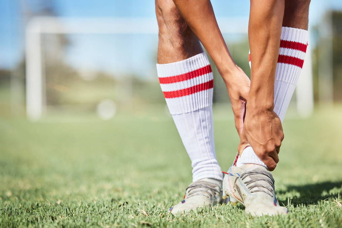 Fußballspielerinnen und -spieler können von einem Bänderriss betroffen sein. / © Getty Images/PeopleImages