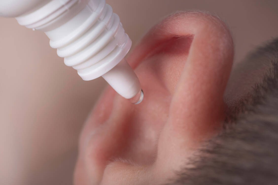 In the case of an ear canal infection that is treated with ear drops, those affected should lie down for ten to 15 minutes after using the medication so that the drops do not immediately run out of their ears again. / Foto: Adobe Stock/Pavel Iarunichev