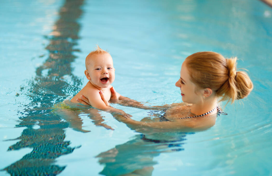 Viele Babys lieben Wasser. Im öffentlichen Schwimmbad sollten sie allerdings besser erst planschen, wenn die Impfung gegen Rotaviren abgeschlossen ist. / Foto: Getty Images/evgenyatamanenko