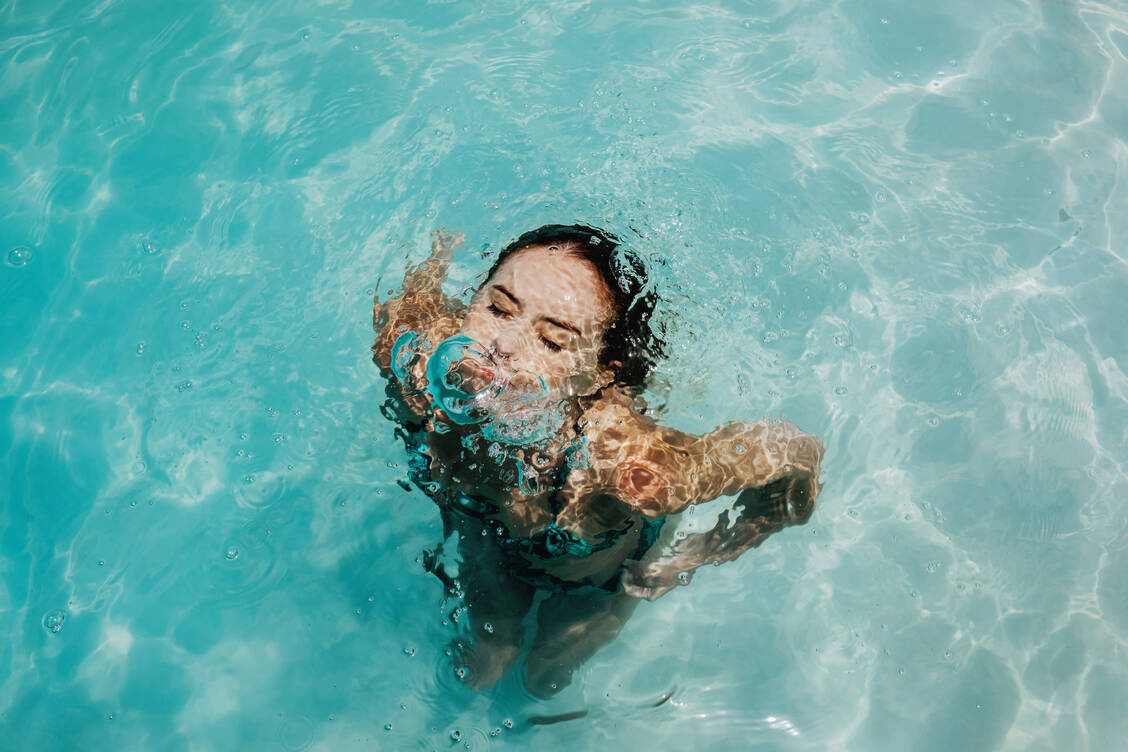 Auch wenn Poolwasser klar aussieht, können sich darin krankmachende Mikroorganismen tummeln. / © Getty Images/Smile/Infidels Photo Agency