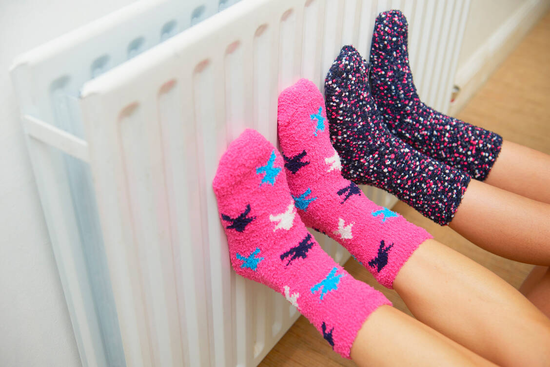 Dicke Socken statt Heizung: So wollen viele im kommenden Herbst und Winter Energie und Kosten sparen. Doch allzu frisch sollte es in der Wohnung auch nicht sein, dann steigt die Gefahr, dass sich Schimmel bildet. / Foto: Getty Images/Peter Dazeley