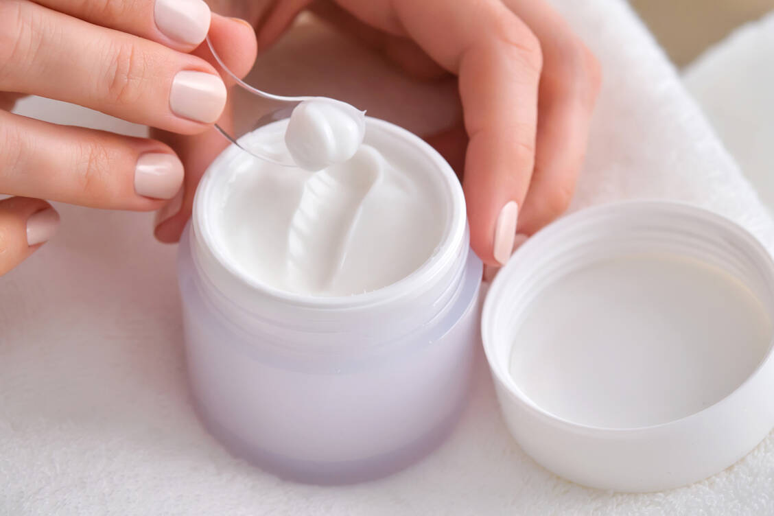 Der Hygiene wegen: Ist die Basispflege in einem Tiegel verpackt, immer mit einem Spatel entnehmen. / © Getty Images/Mariya Borisova