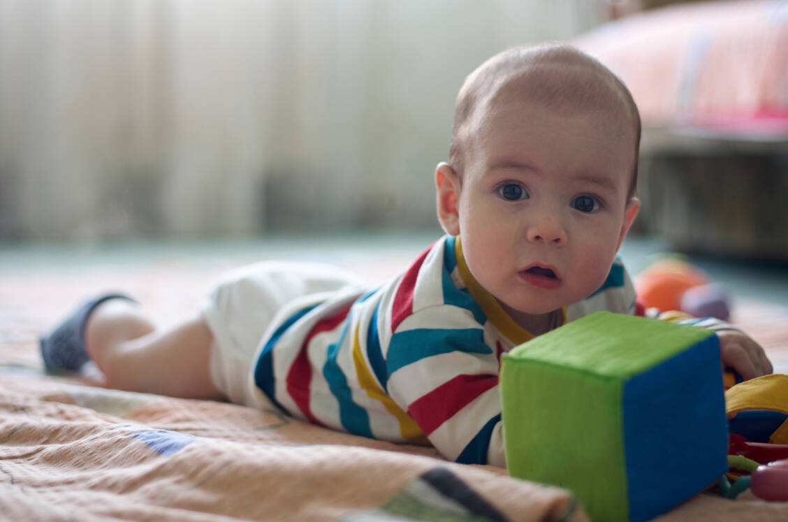 Im wachen Zustand sollte das Baby so viel wie möglich auf dem Bauch liegen, um die Entwicklung der Kopfkontrolle zu fördern. / Foto: Getty Images/fortise