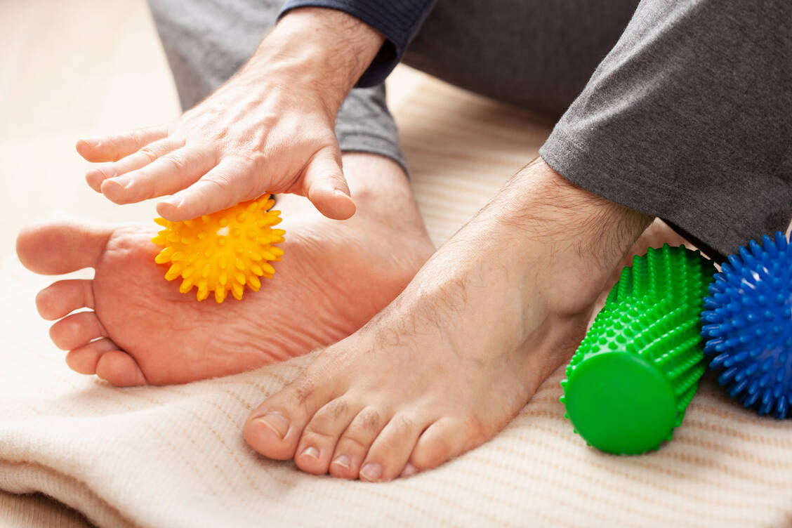 Eine sanfte Fußmassage mit dem Igelball fördert die Durchblutung. / © Adobe Stock/Olga Miltsova