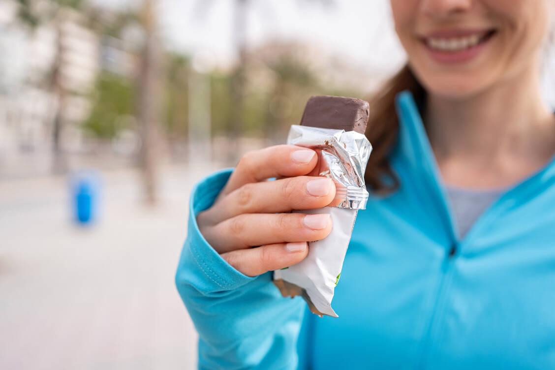 Nach dem Sport ein Proteinriegel, das ist bequem. Hobbysportlerinnen und -sportlern sollte aber klar sein: Ein wirklich gesunder Snack ist das nicht. / © Getty Images/FluxFactory