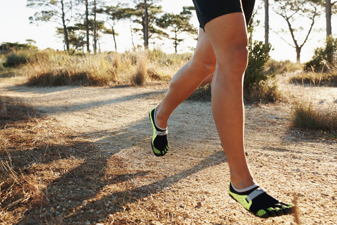 Wer in Barfußschuhen joggen gehen möchte, muss darauf achten, auf dem Vorderfuß aufzukommen.  / © Getty Images/	PeopleImages