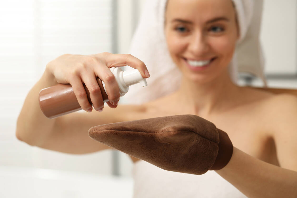 Selbstbräuner wird am besten mit einem Kosmetikhandschuh aufgetragen, um Flecken an den Händen zu vermeiden. / © Adobe Stock/New Africa