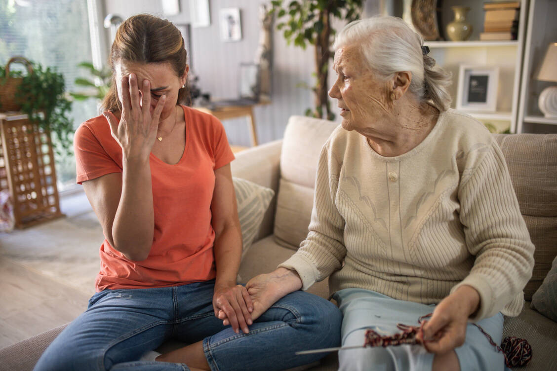 Pflegende Angehörige stehen oft unter enormem Druck. / © Getty Images/zeljkosantrac