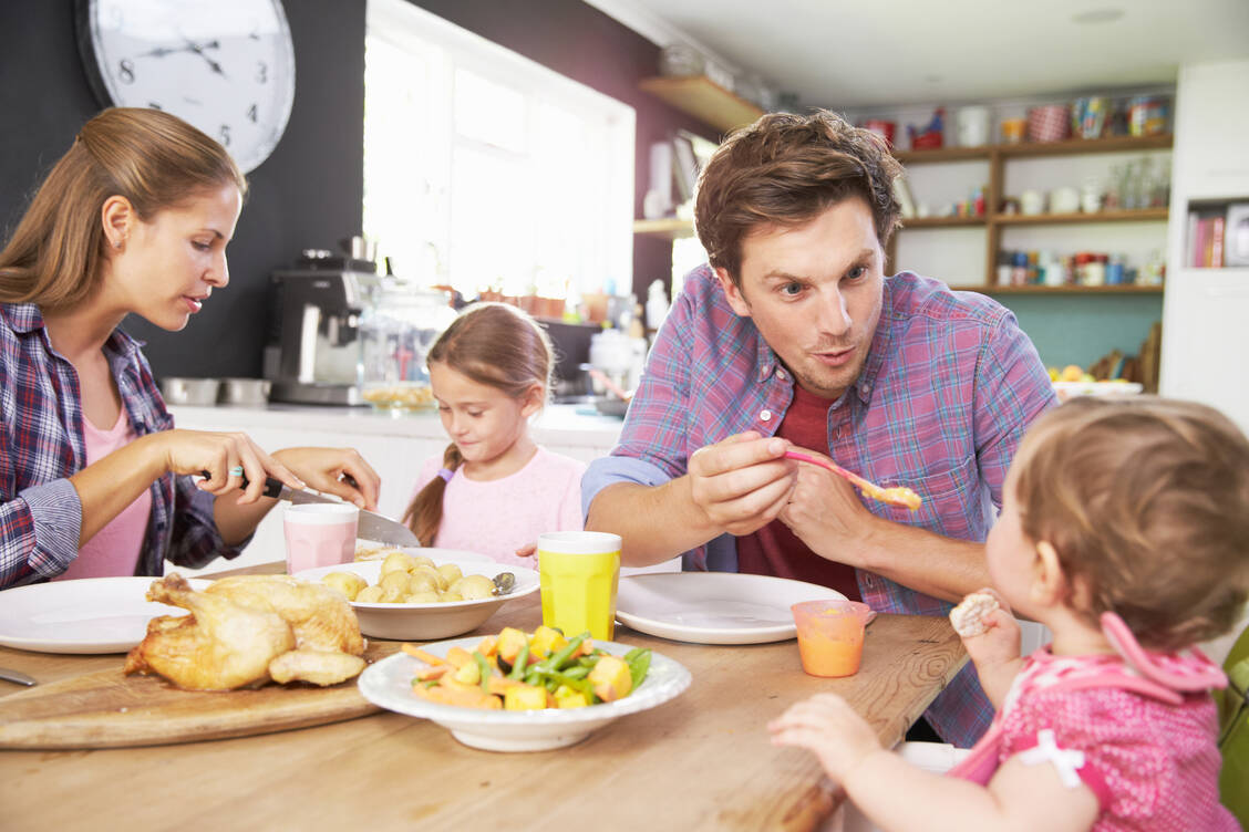 Gegen Ende des ersten Lebensjahres kann das Kind am Familienessen teilnehmen. Die Speisen sollten aber nicht zu stark gesalzen und gewürzt werden. / Foto: Adobe Stock/Monkey Business
