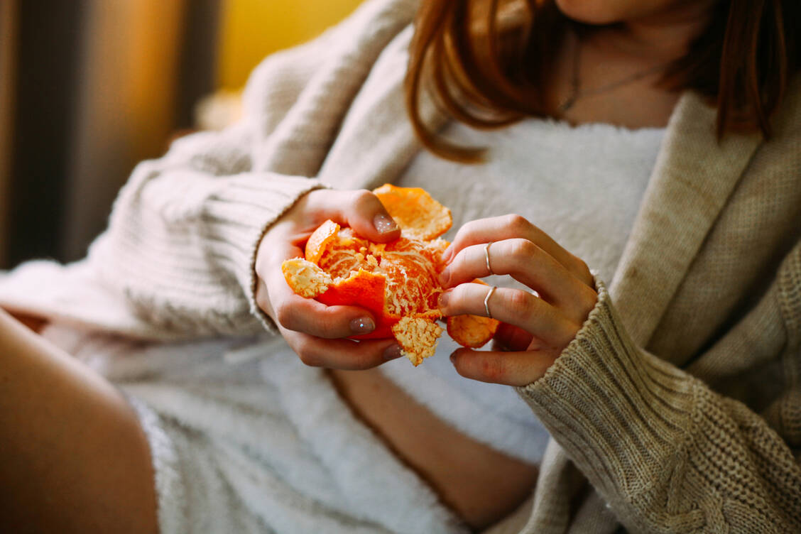 Zitrusfrüchte wie Mandarinen sollten nicht zu genau geschält werden. Es ist sogar gesund, wenn weiße Reste am Fruchtfleisch hängen bleiben und mitverzehrt werden. / Foto: Getty Images/Anna Blazhuk