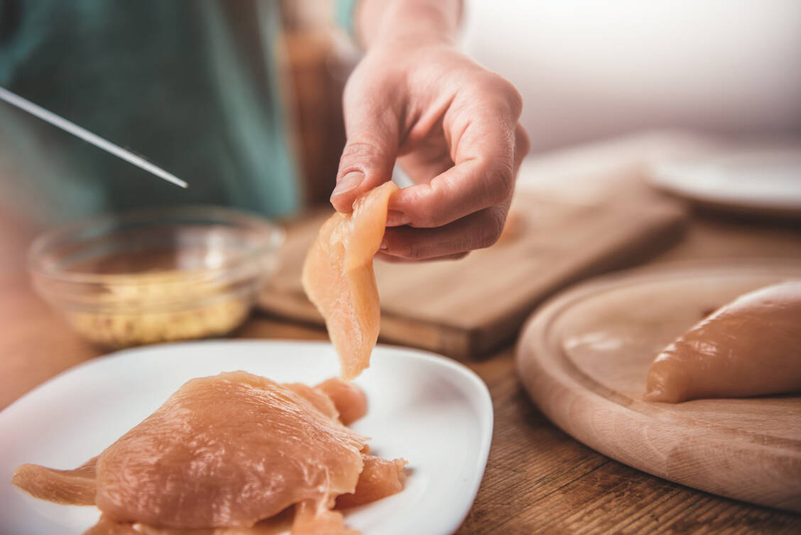 Bei der Zubereitung beispielsweise von Hühnchen sollten unterschiedliche Bretter und Messer für das Fleisch und andere, roh verzehrte Lebensmitteln wie Salat verwendet werden.  / Foto: Getty Images/Kerkez