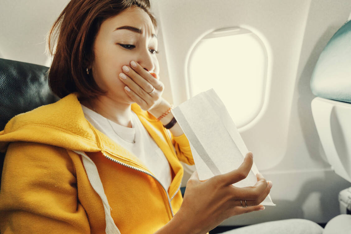 Reiseübelkeit kann einen auch im Flugzeug erwischen. Hier empfiehlt sich unter anderem, am Fenster auf Höhe der Tragflächen zu sitzen. / Foto: Adobe Stock/EdNurg
