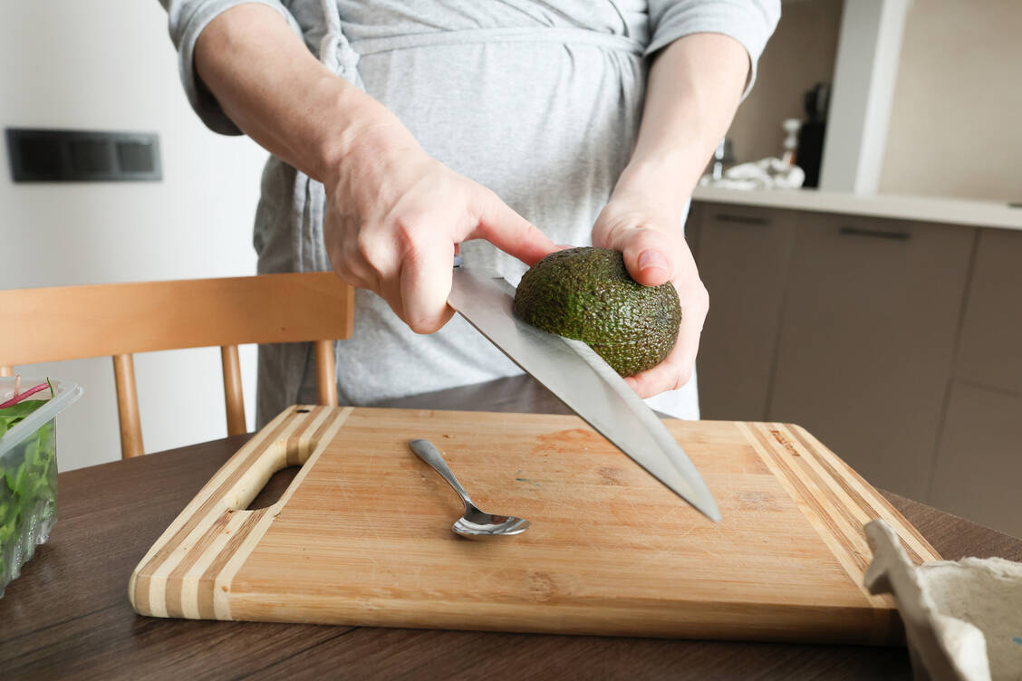 Beim Schneiden von Avocados können gefährliche Schnittverletzungen entstehen. / © Getty Images/KNataliia
