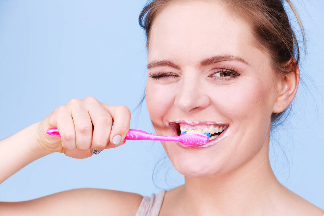 Zweimal täglich die Zähne mit einer fluoridhaltigen Zahncreme zu putzen hilft nachweislich Karies vorzubeugen.  / © Getty Images/Voyagerix