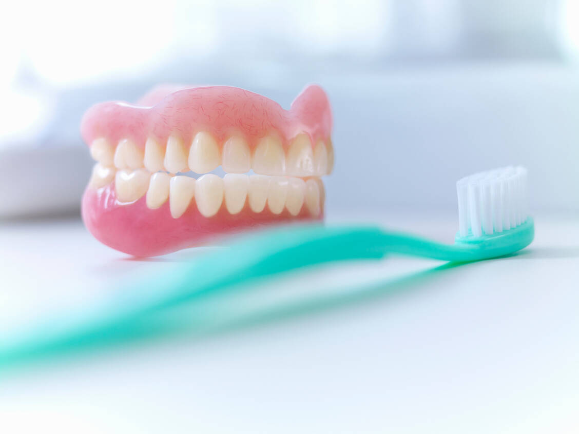 Bei der Reinigung von Zahnprothesen lauern Fallstricke. / © Adobe Stock/Adam Gault/KOTO