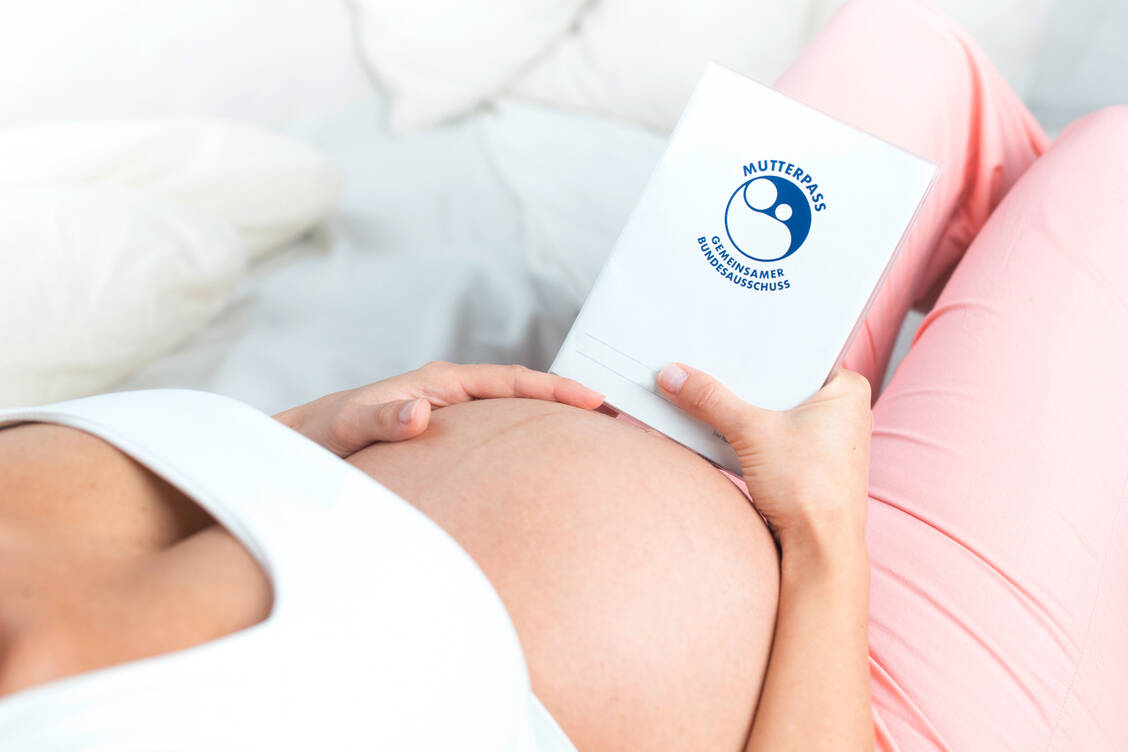 Im Mutterpass sind die Untersuchungen und Vorsorgeuntersuchungen aufgeführt, die laut Mutterschafts-Richtlinien für GKV-Versicherte angeboten werden. Ärzte dokumentieren im Pass den Gesundheitszustand der Schwangeren, den Verlauf der Schwangerschaft und gegebenenfalls Komplikationen. / Foto: Adobe Stock/mmphoto